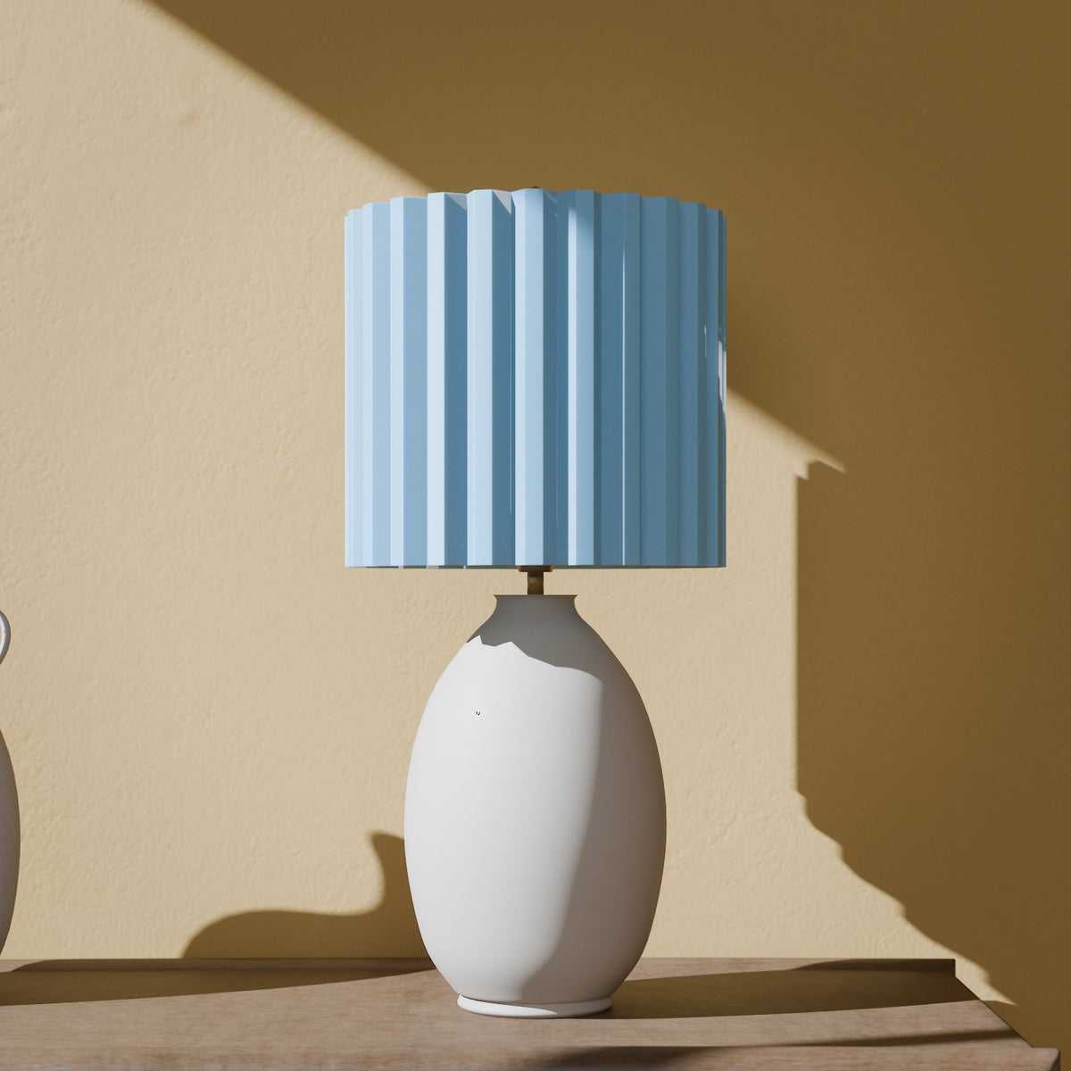 Glow-in-the-dark pleated lamp shade in Glow Blue on a table lamp