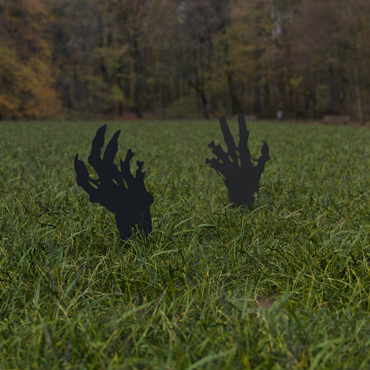Two zombie hand silhouette yard stakes reaching up out of a lawn